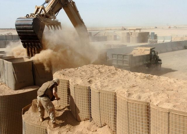 Наполнение HESCO bastion песком с помощью экскаватора