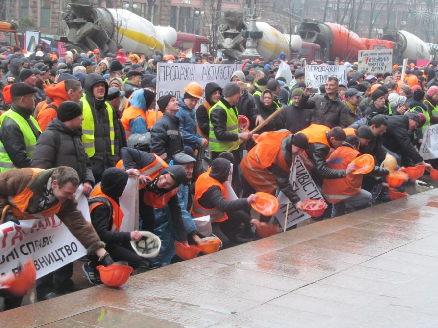 Строители бьют касками по мостовой на митинге строителей в Киеве