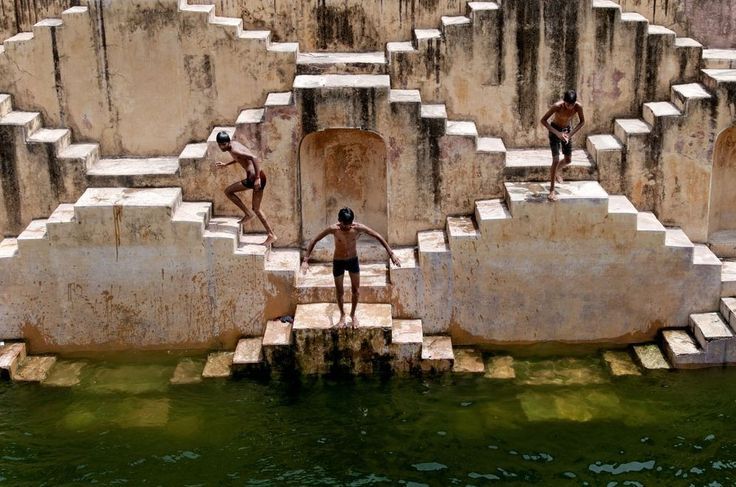Мальчишки купаются  в ступенчатом колодце Чанд Баори (Chand Baori stepwell)